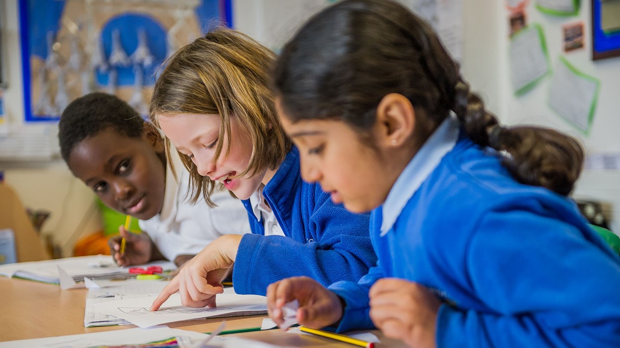 Happy  primary school children in a classroom, built by Skanska