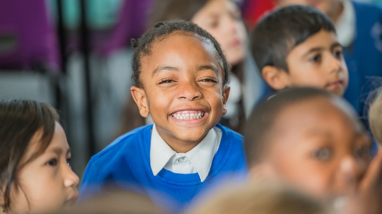 Happy  primary school children in a classroom, built by Skanska