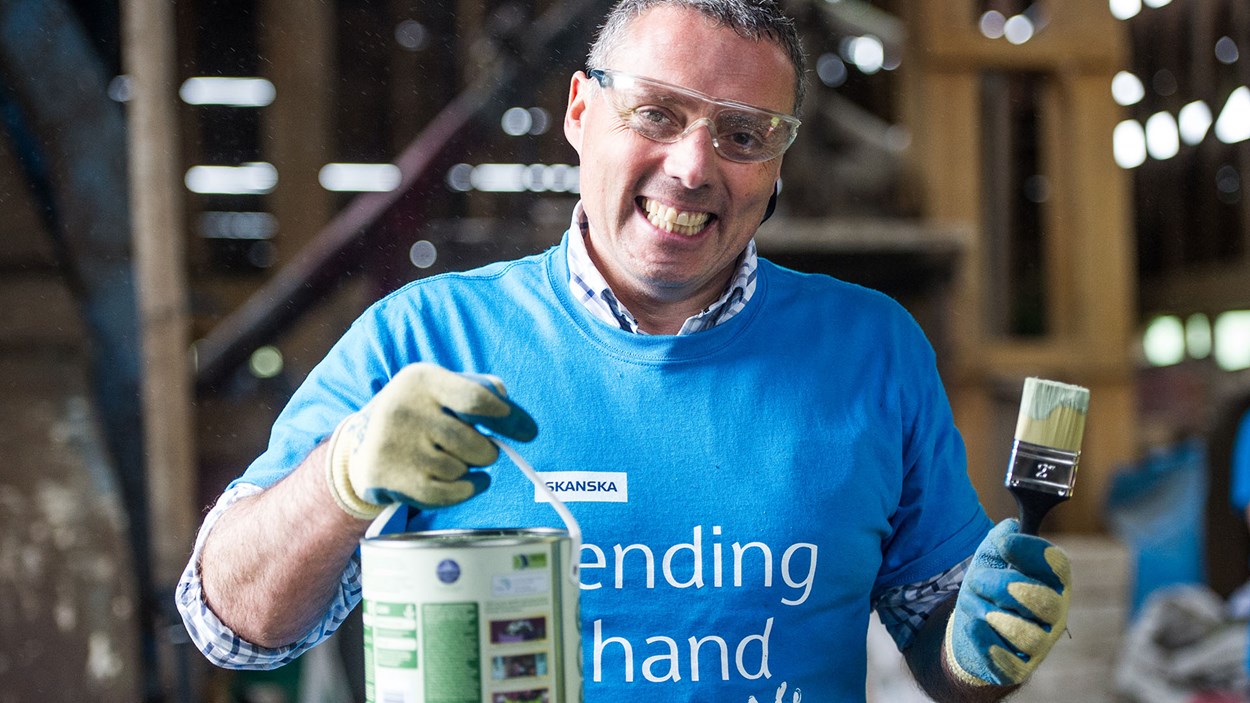 A Skanska volunteer with a pain can and brush at a community project