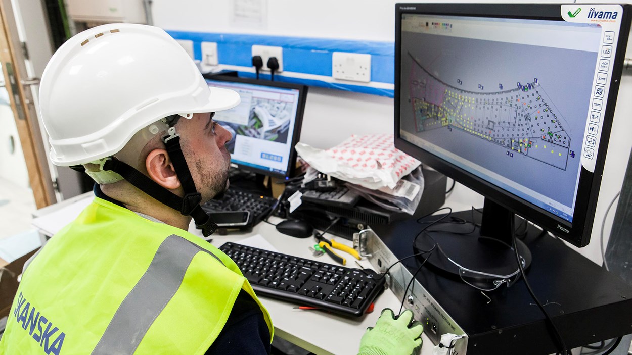 A Skanska engineer looks at a 3D model on a computer