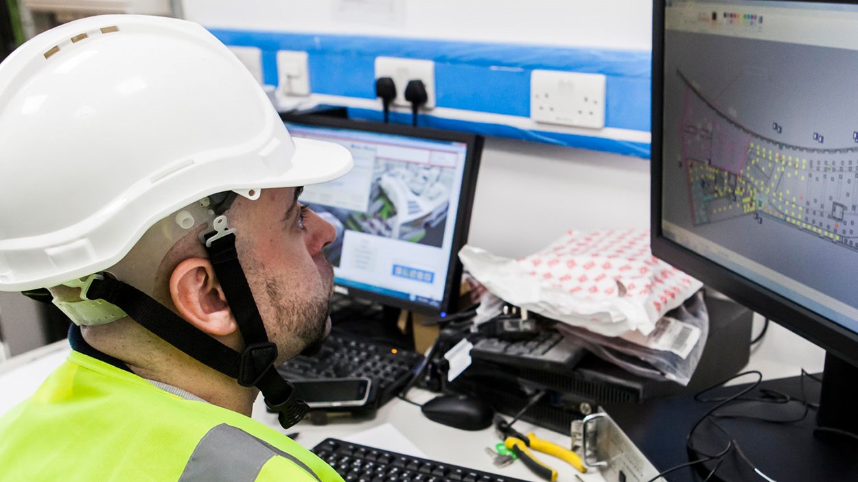 A Skanska engineer looks at a 2D plan on a computer