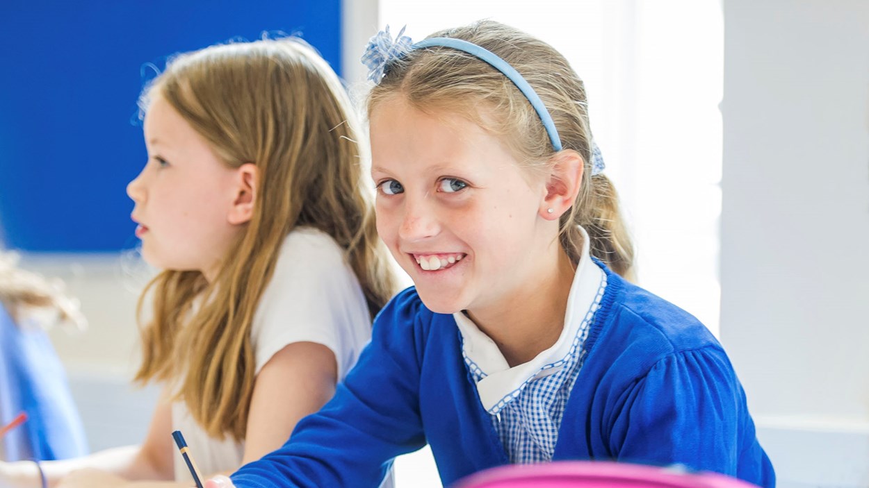 A girl writing in a classroom