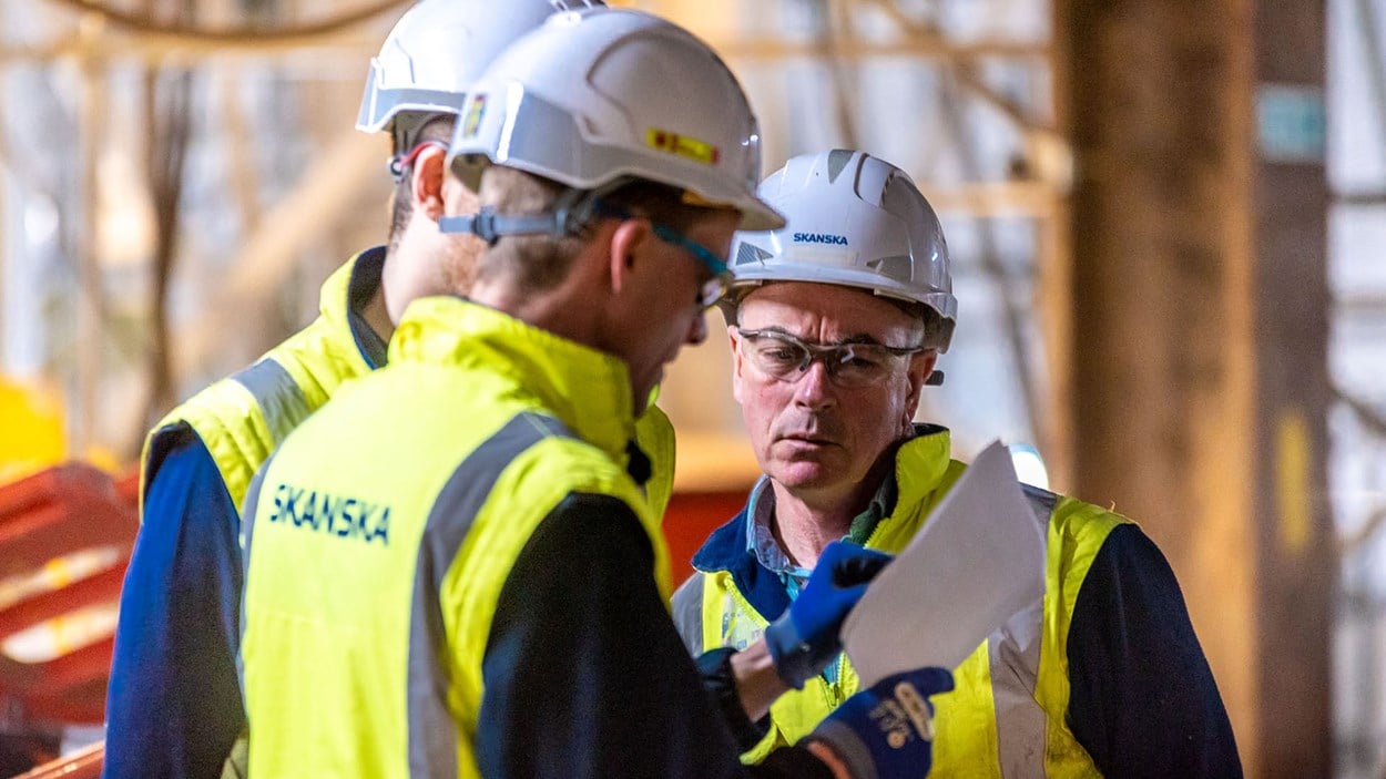 Skanska construction workers hold a discussion at a project