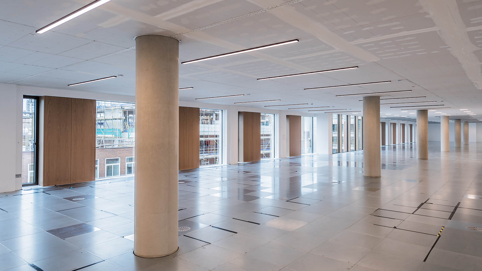 One of the office floor levels with a raised floor, circular visual concrete columns and a chilled plasterboard ceiling.