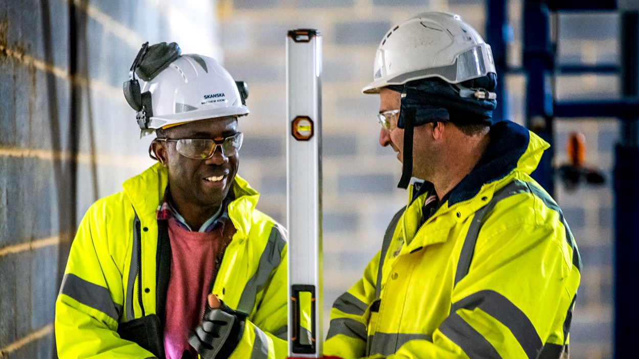 Two people from Skanska talking together, on a construction site at Worthy Down