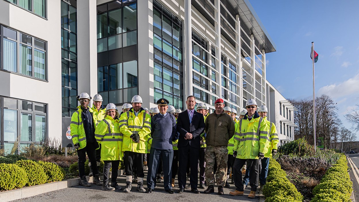 Members of the armed forces with the Skanska construction team in front of the newly built Royal College of Policing, Logistics and Administration