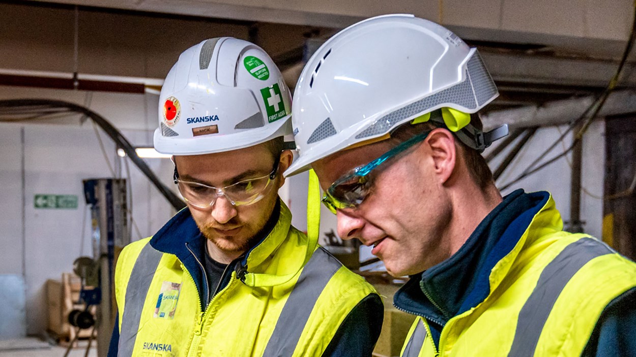 Two construction workers have a meeting on site