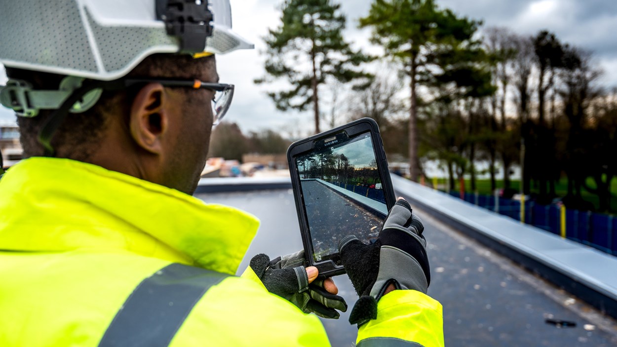 A Skanska construction worker at Worthy Down uses a tablet on site