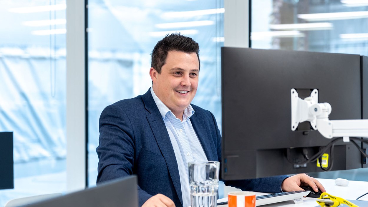 A person in a Skanska office, working at a computer