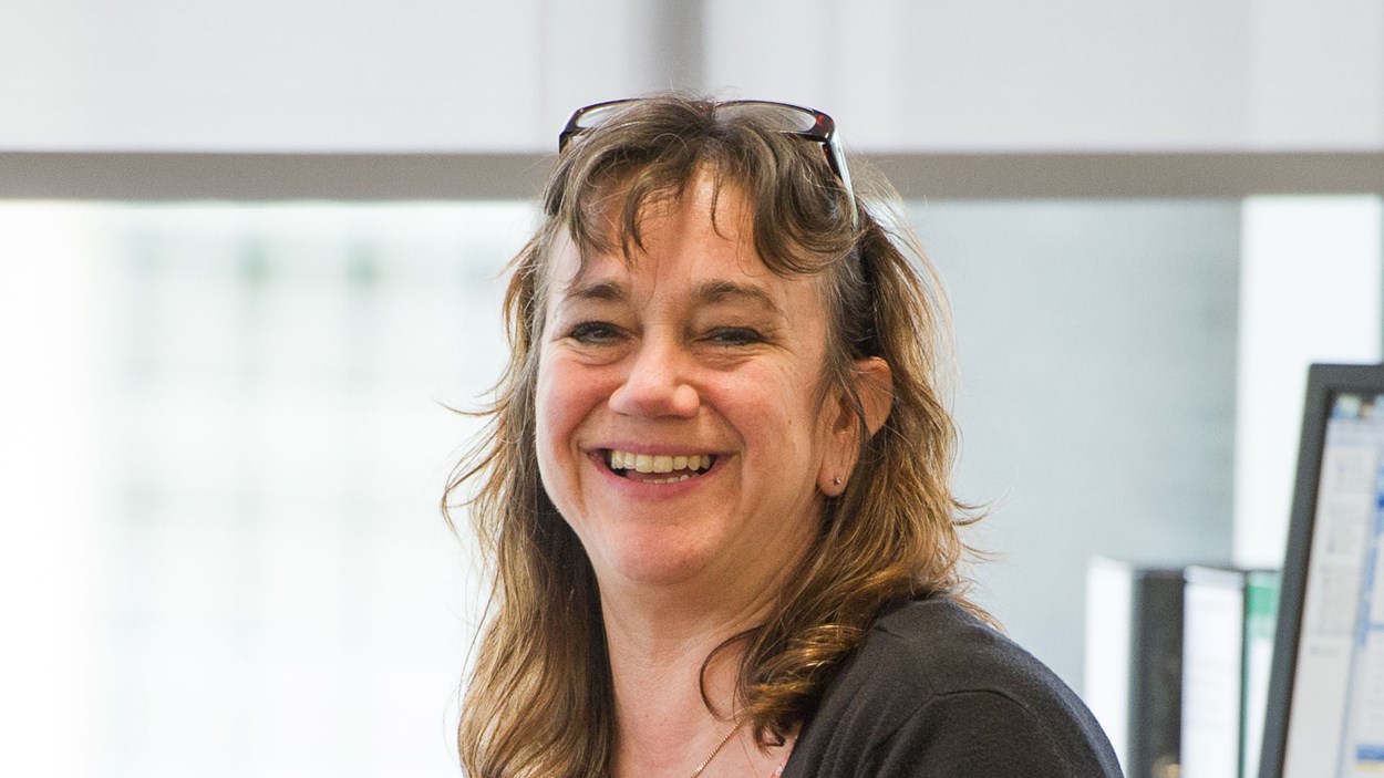 A smiling woman, in an office