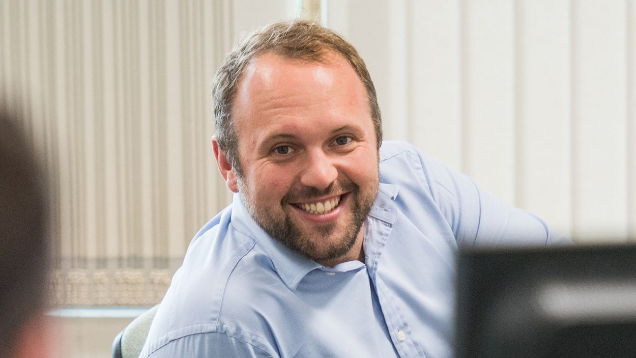 A happy man, working a computer